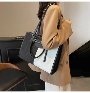 Detail of color-block canvas tote bag with leather trim and front zip pocket