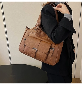 Close-up of vintage brown PU leather tote bag with flap pocket and metal buckle details