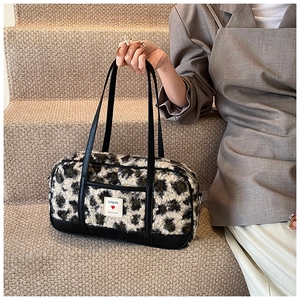 Detail of leopard print faux fur tote bag with black straps and branded woven label