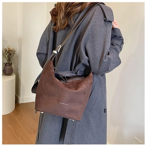 Detail of dark coffee suede shoulder bag with leather strap and silver bottom studs
