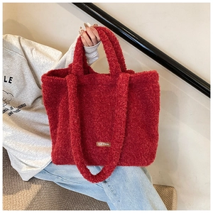 Detail of red plush tote bag with fuzzy texture and our fave leather brand label