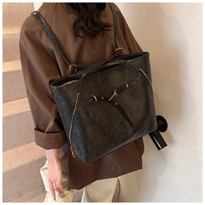 Detail view of vintage oil-wax leather tote bag showing side metal zippers and dual straps