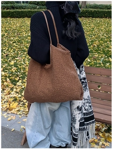 Brown fluffy teddy fleece tote bag with leather straps worn outdoors in autumn