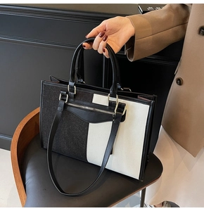 Detail of color-block tote bag with metal zipper and detachable shoulder strap