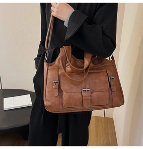 Brown vintage PU leather tote bag with metal buckle detail shown on a model