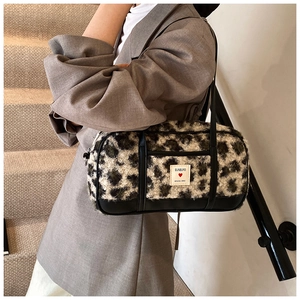 Detail of leopard print plush barrel bag with leather trim and logo on long shoulder strap