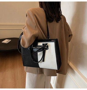 Detail of minimalist black and white tote bag with fringe zipper and shoulder straps