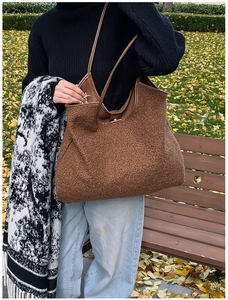 Brown fluffy tote bag with leather straps shown in a seasonal autumn park setting