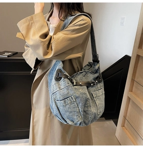 Detail of blue denim shoulder bag showing silver rivets and black leather drawstring