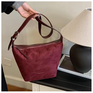 Detail of burgundy large capacity soft faux leather shoulder bag with zipper and logo
