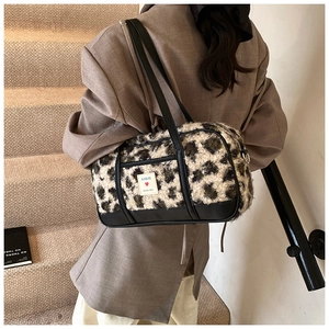 Chic leopard print plush shoulder bag with leather trim on model at a staircase