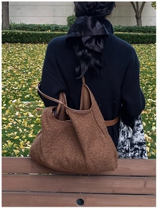 Detail of a dark brown hobo shoulder bag in soft sherpa fleece fabric for autumn style