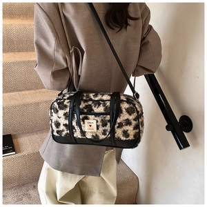 Detailed view of leopard print plush bucket bag with adjustable black leather strap