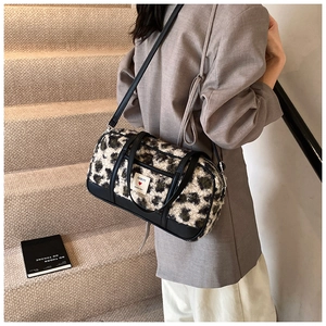 Detail of leopard print faux fur Boston bag with black leather handles and shoulder strap