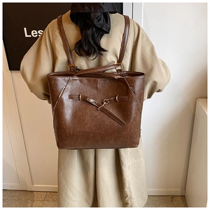 Deep brown oil wax leather large backpack shown on a model in a minimal indoor setting