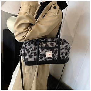 Detail of leopard print faux fur shoulder bag with leather trim and branded logo tag