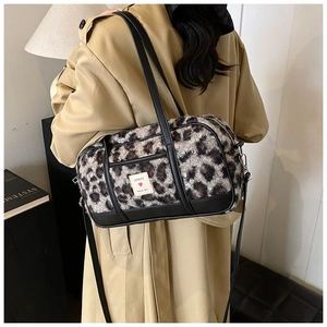 Detail of plush leopard print shoulder bag featuring high-quality faux fur and black leather