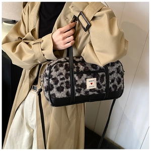 Detail of grey leopard faux fur texture and branded woven label on women's shoulder bag