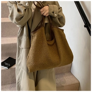 Detail of caramel teddy fleece tote bag featuring brown faux leather handles and texture