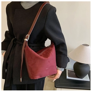 Close-up of burgundy hobo shoulder bag with matte texture and fashion text detail