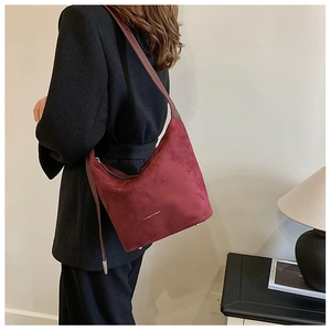 Detail of vintage dark red faux leather shoulder bag featuring embossed fashion logo