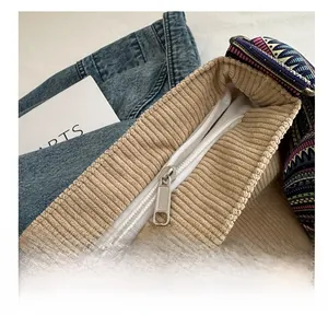 Gros plan sur le sac en velours côtelé beige avec zip fluide et sangle tissée
