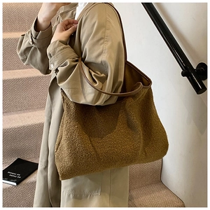 Brown fuzzy shearling tote bag with leather straps worn with a stylish trench coat