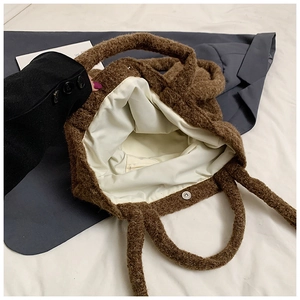 Close-up of brown plush tote bag showing inner lining and magnetic buckle closure