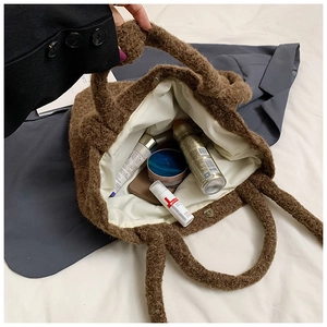 Detail shot of plush brown tote bag showing magnetic closure and internal storage space