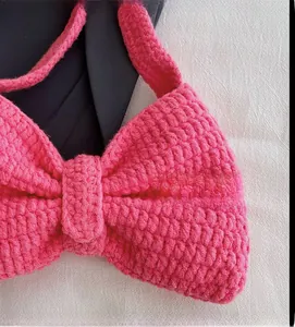 Détail du sac noeud rose tricoté main montrant la texture crochet et le fil