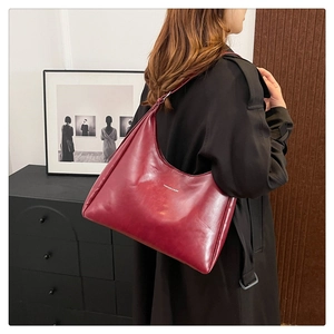 Detail view of burgundy PU tote bag with FASHION & BAGS logo worn by a model