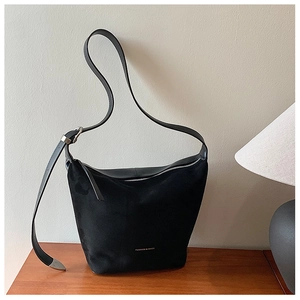 Minimalist black matte leather shoulder bag with adjustable strap and silver metal hardware