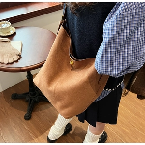 Détail du sac cabas en daim marron doté d'un fermoir tournant cylindrique doré de haute qualité