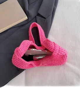 Détail intérieur d'un sac à bandoulière en tricot rose montrant l'espace de rangement