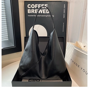 Minimalist black leather tote bag with a spacious hobo design for women commuting