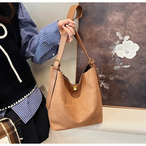 Détails de la texture du sac hobo en daim marron avec fermoir doré élégant