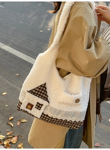 Gros plan sur un sac en peluche blanc avec décor de maison à carreaux et dentelle