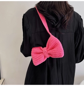 Détail d'un sac à bandoulière en crochet fait main en forme de nœud rose vif