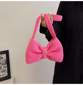 Gros plan du sac à main nœud en tricot rose vif avec texture crochetée et bandoulière