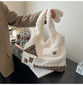 Détail du cabas en peluche blanche avec applique de maison et accents de carreaux