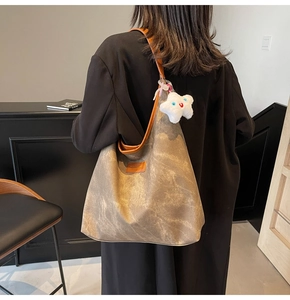 Brown washed texture tote bag on model shoulder with white star plush charm detail