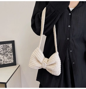 Détail du sac à bandoulière en maille crème avec un grand nœud fait main