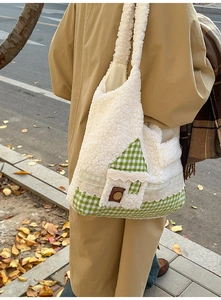 Détail du sac fourre-tout en peluche avec poche en forme de maison et motif à carreaux