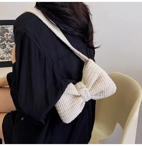 Détail du sac à bandoulière en crochet crème avec grand nœud 3D et texture tricotée