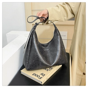 Close-up of dark grey PU leather tote bag showing vintage texture and adjustable strap