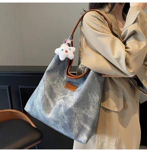 Detail view of large marble texture tote bag with brown trim and star pendant