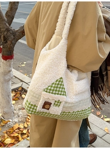 Détail du sac bandoulière en peluche avec base à carreaux verts et motif maison en dentelle
