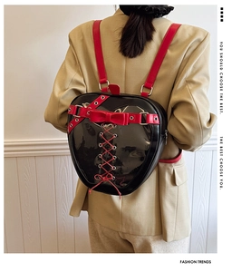 Detail of gothic ita bag showing heart window and red bow on black patent leather