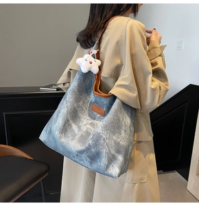 Blue denim texture tote bag with brown leather handles and a plush white star charm