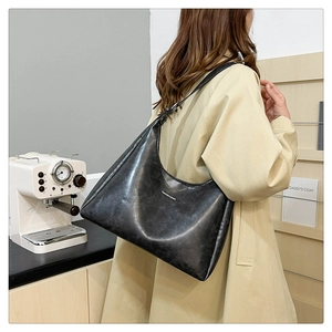 Detail of minimalist black PU hobo bag with Fashion & Bags print carried by a model